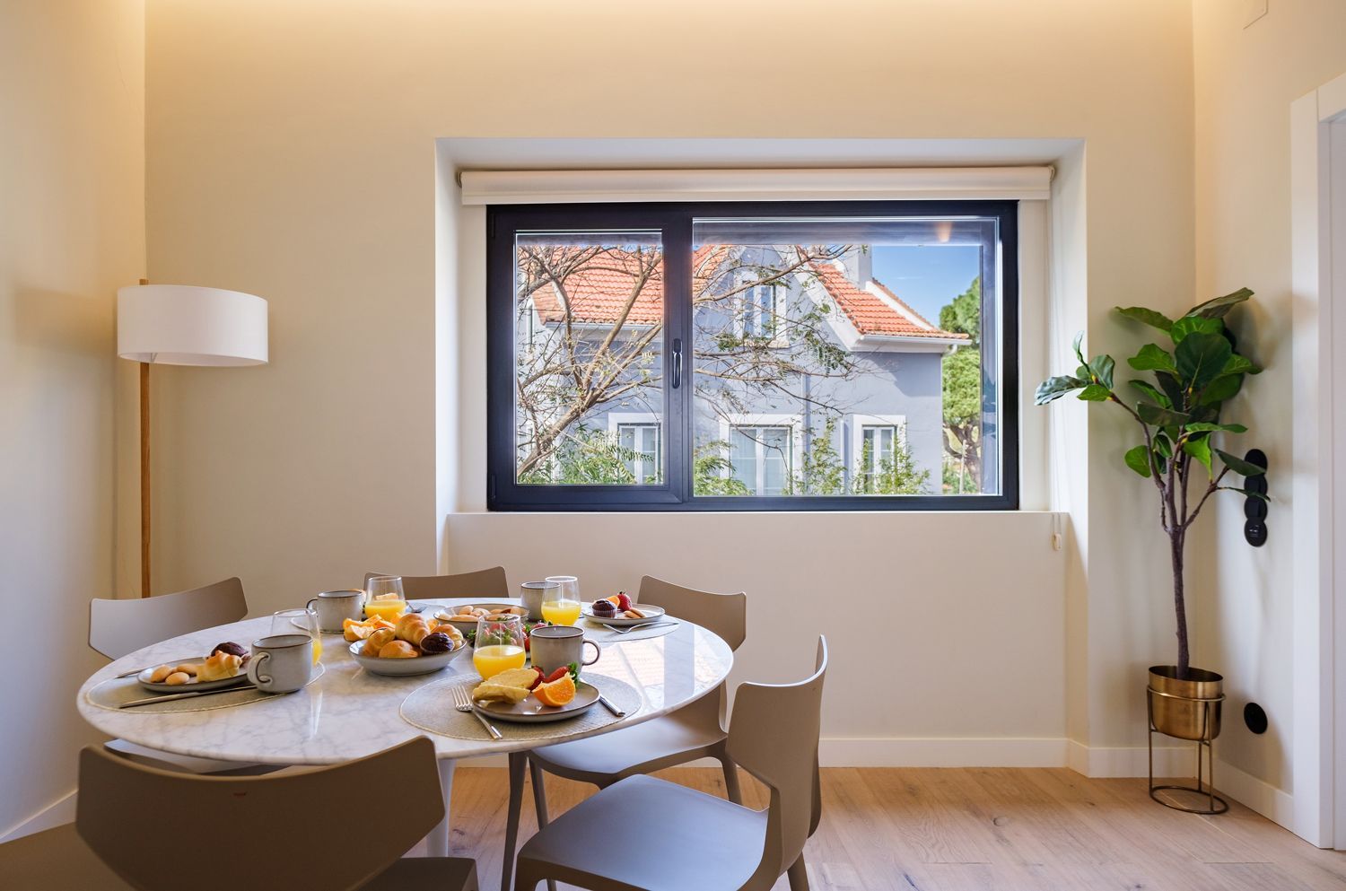 A dining room with a table and chairs and a large window.