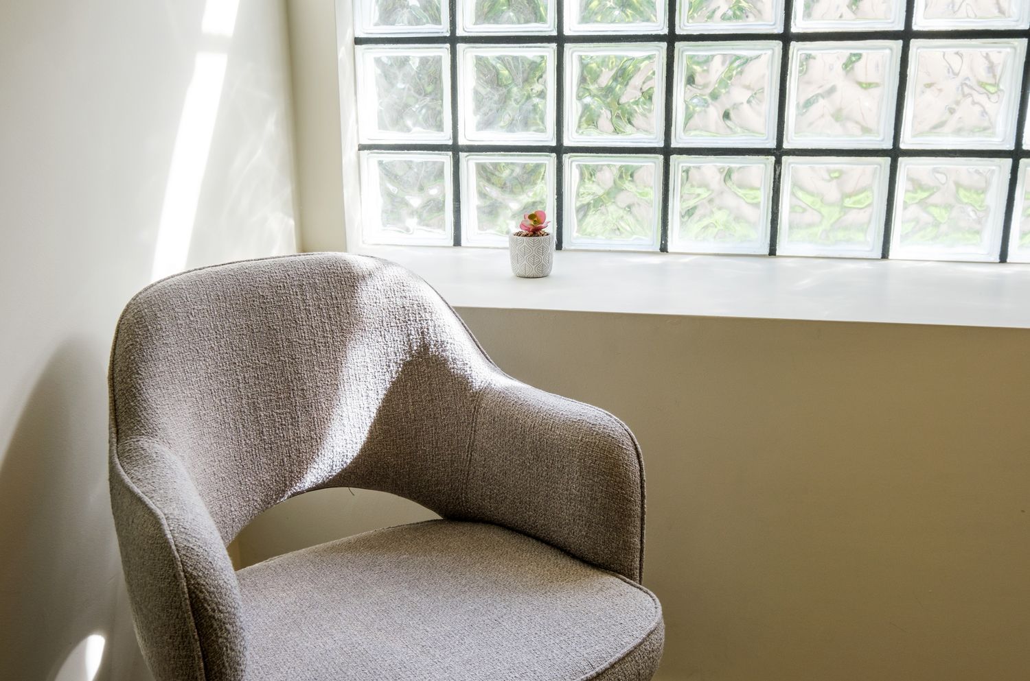 A chair is sitting in front of a window in a room.