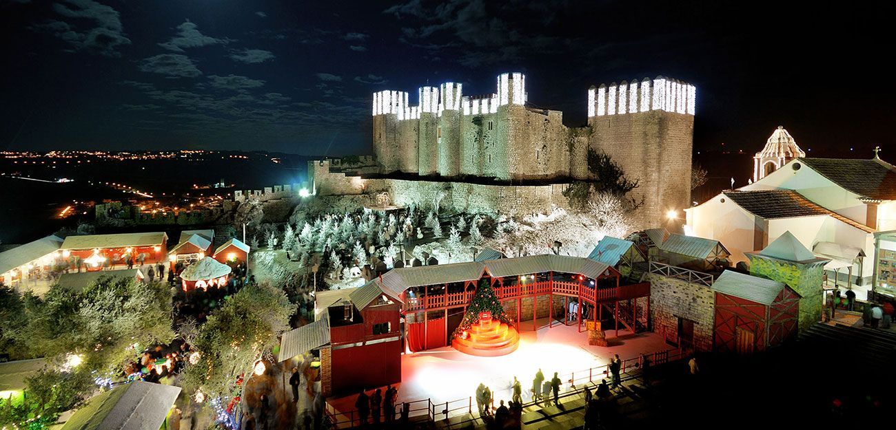 An aerial view of a castle lit up at night