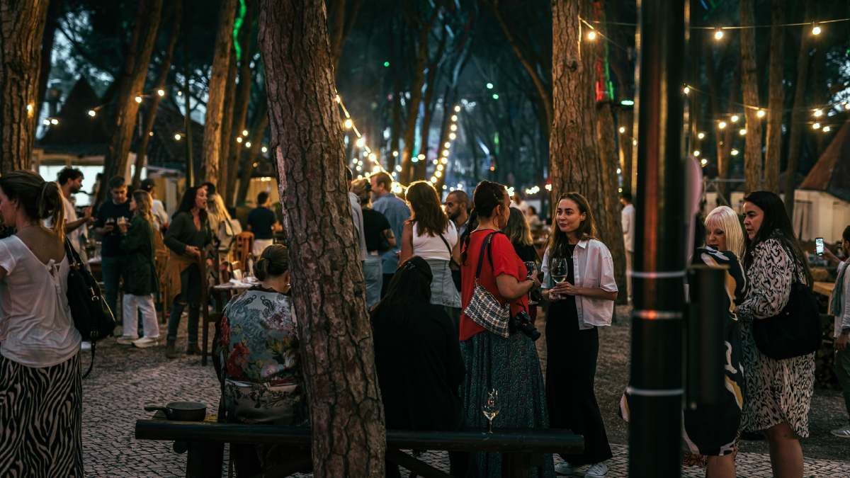 A group of people are standing around a tree in a forest.