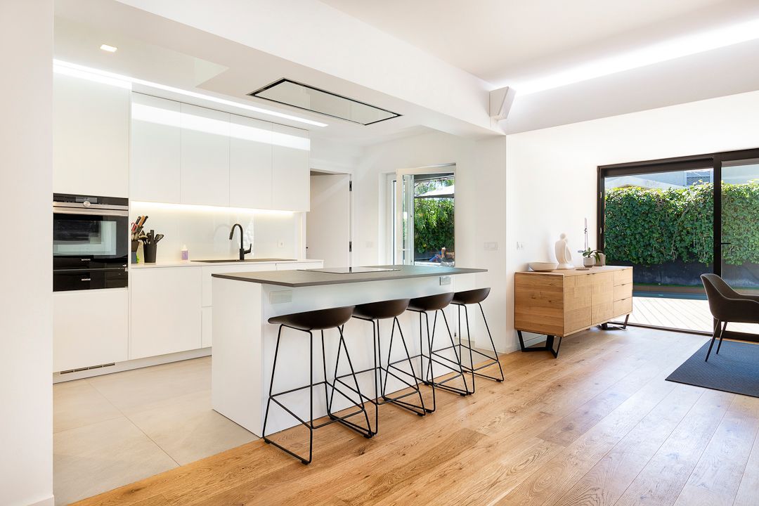 A kitchen with a large island and stools in it