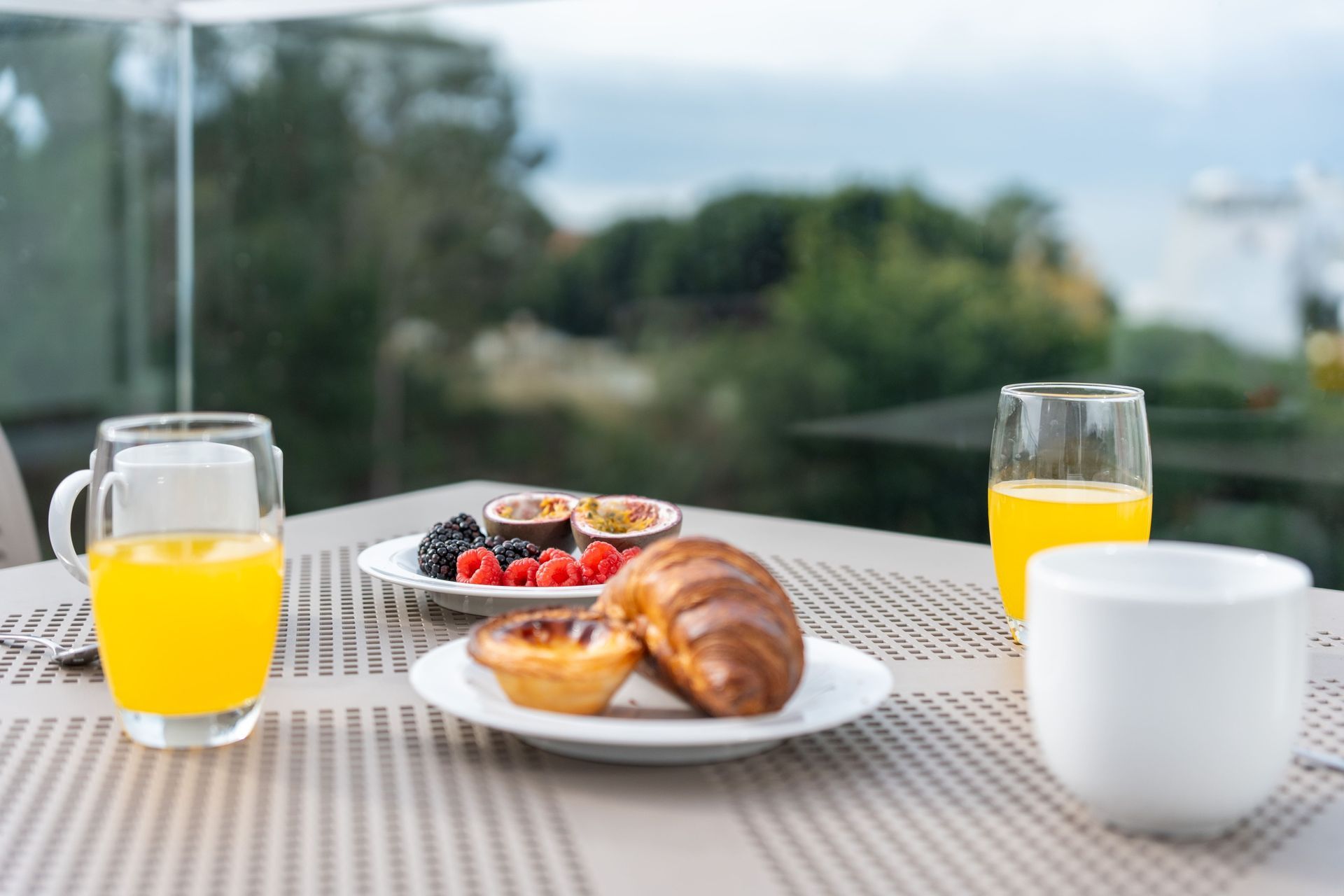 A table topped with a plate of food and a glass of orange juice.