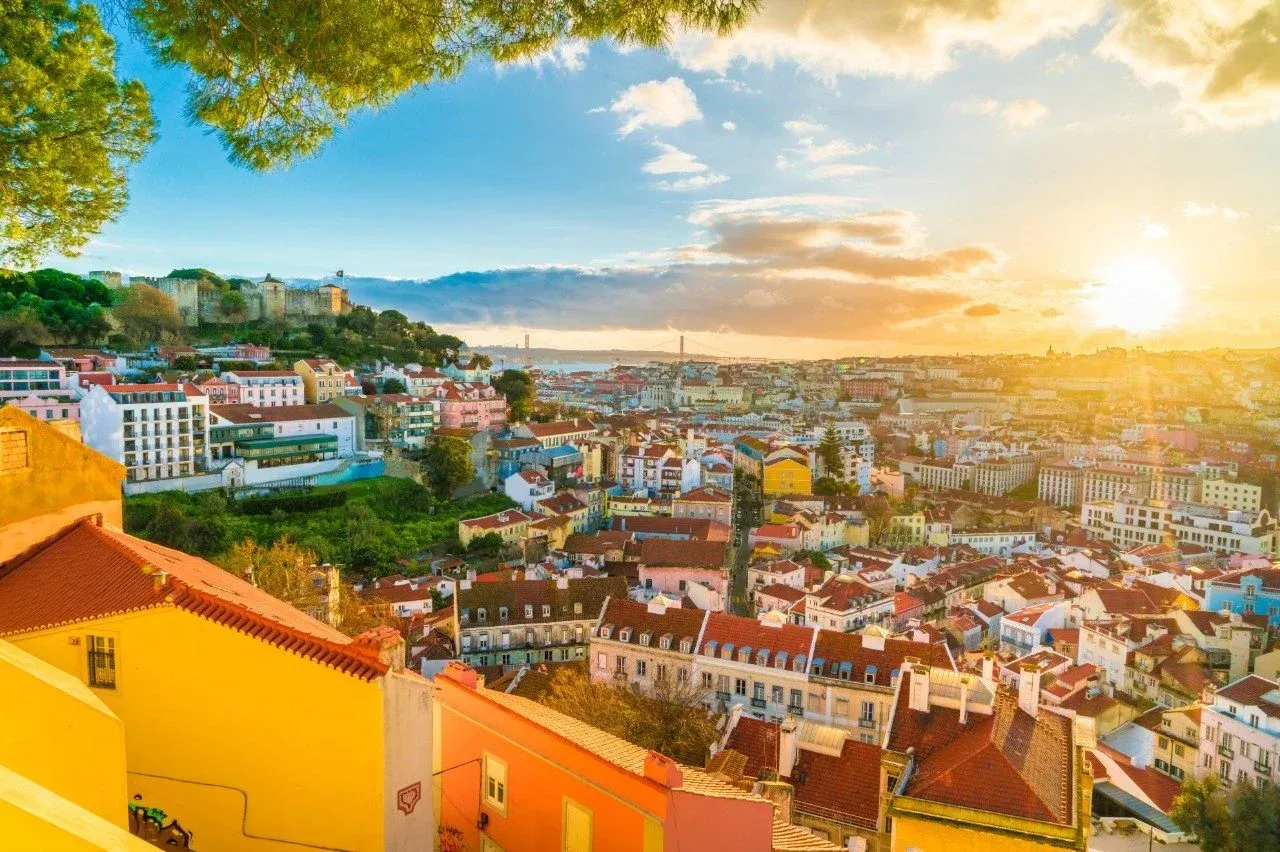 An aerial view of a city with a sunset in the background.