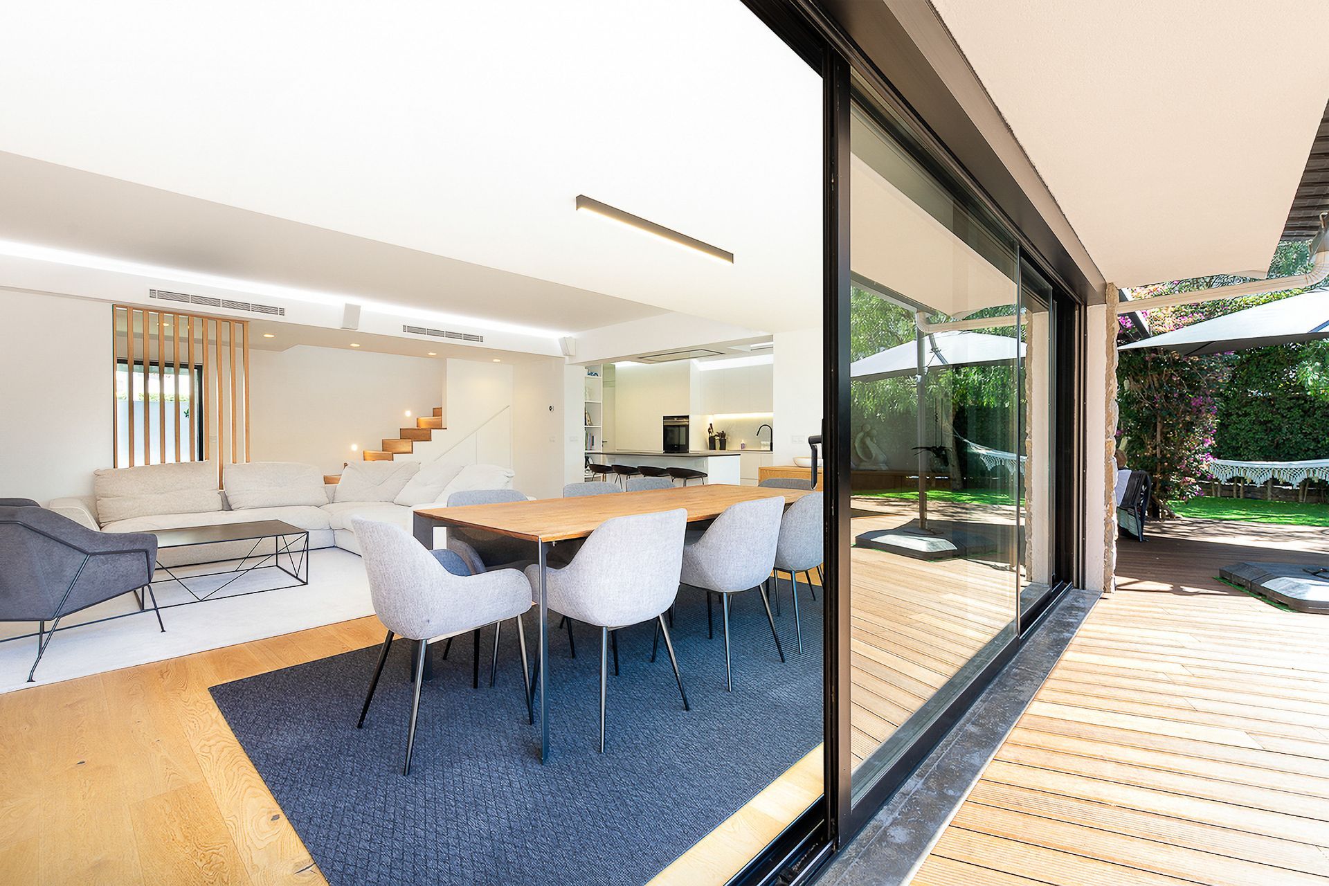 A living room with a table and chairs and a sliding glass door leading to a dining room.