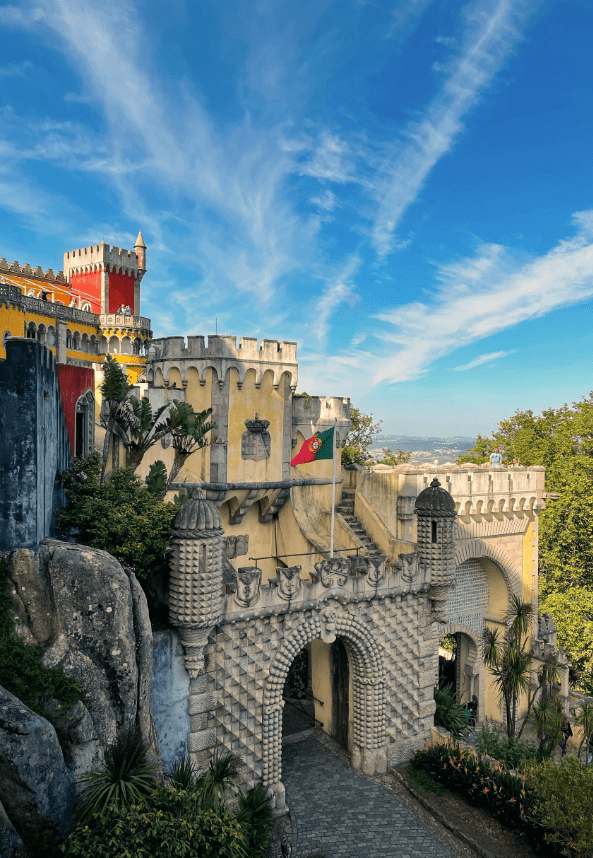 a castle with two flags flying in front of it Sintra Holiday Homes