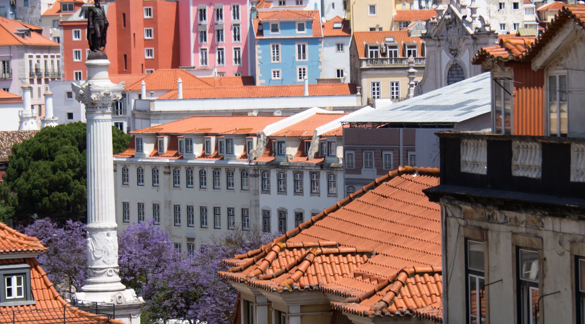 A cityscape with a statue in the middle of it