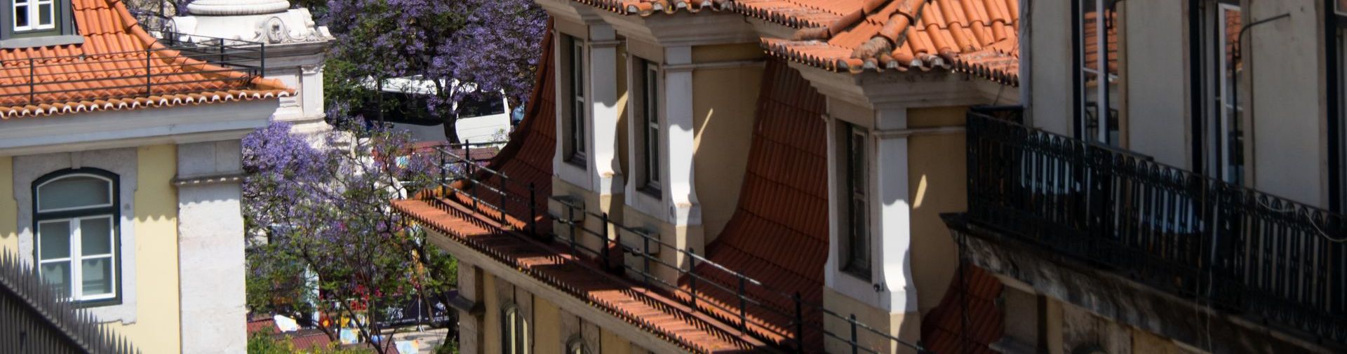 A row of buildings with red tile roofs and balconies