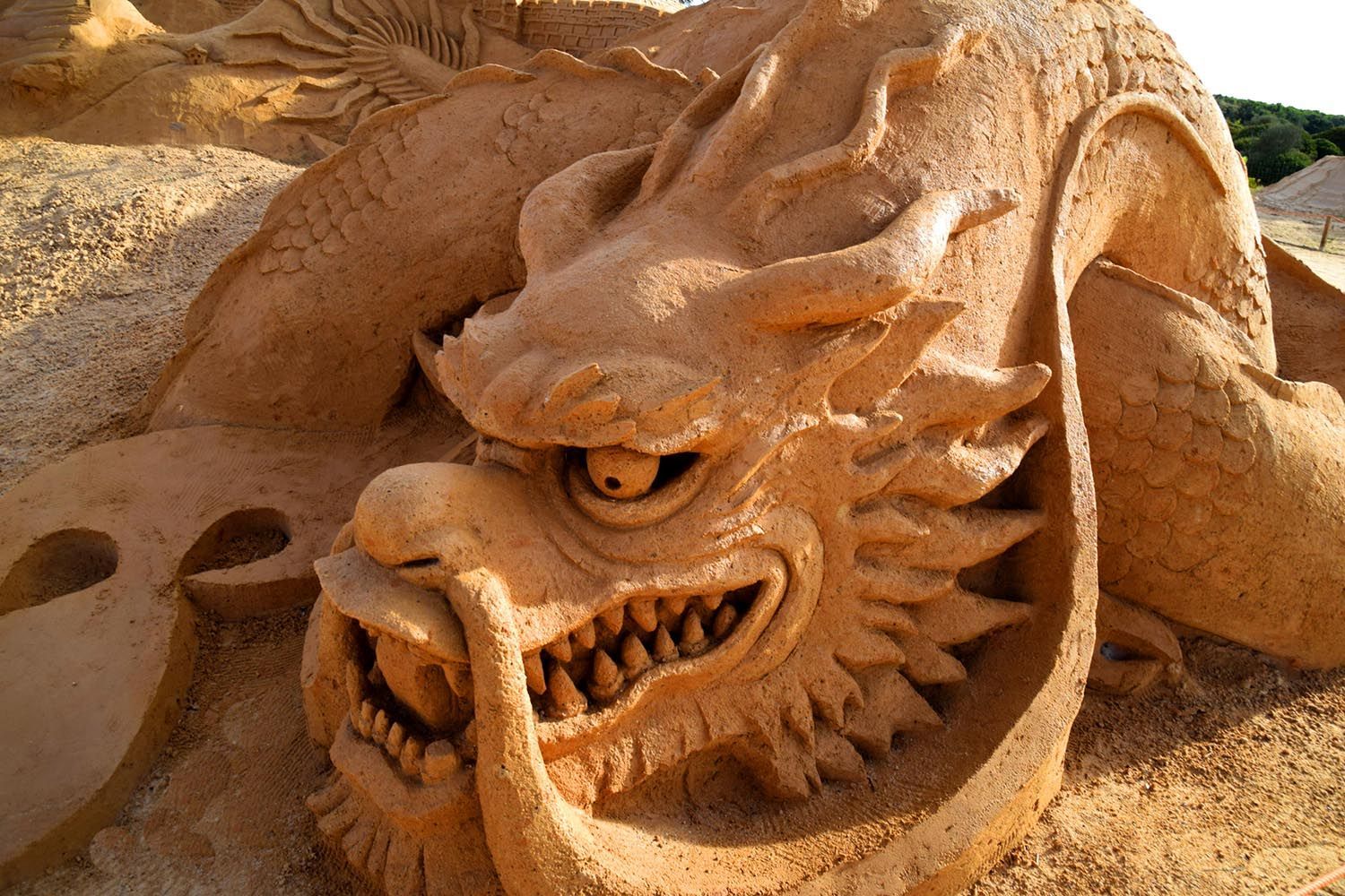 A close up of a sand sculpture of a dragon