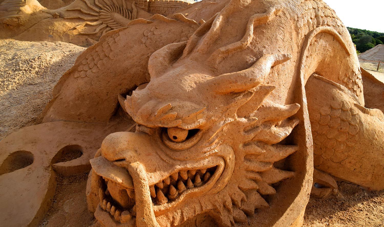 A close up of a sand sculpture of a dragon