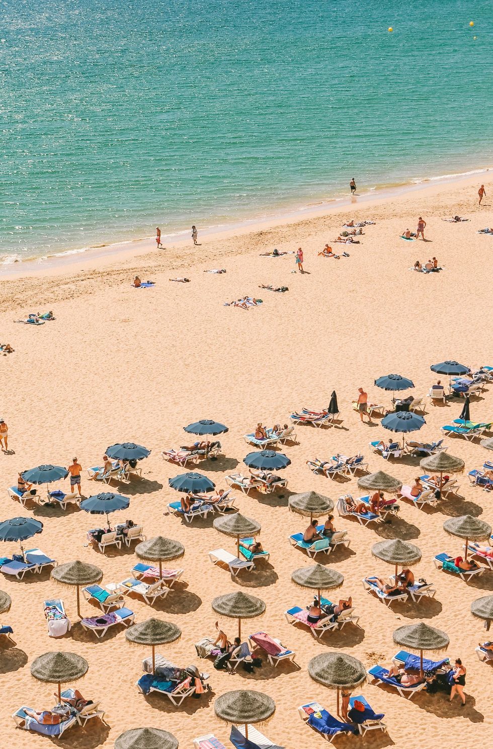 A family beach with straw umbrellas in the Algarve