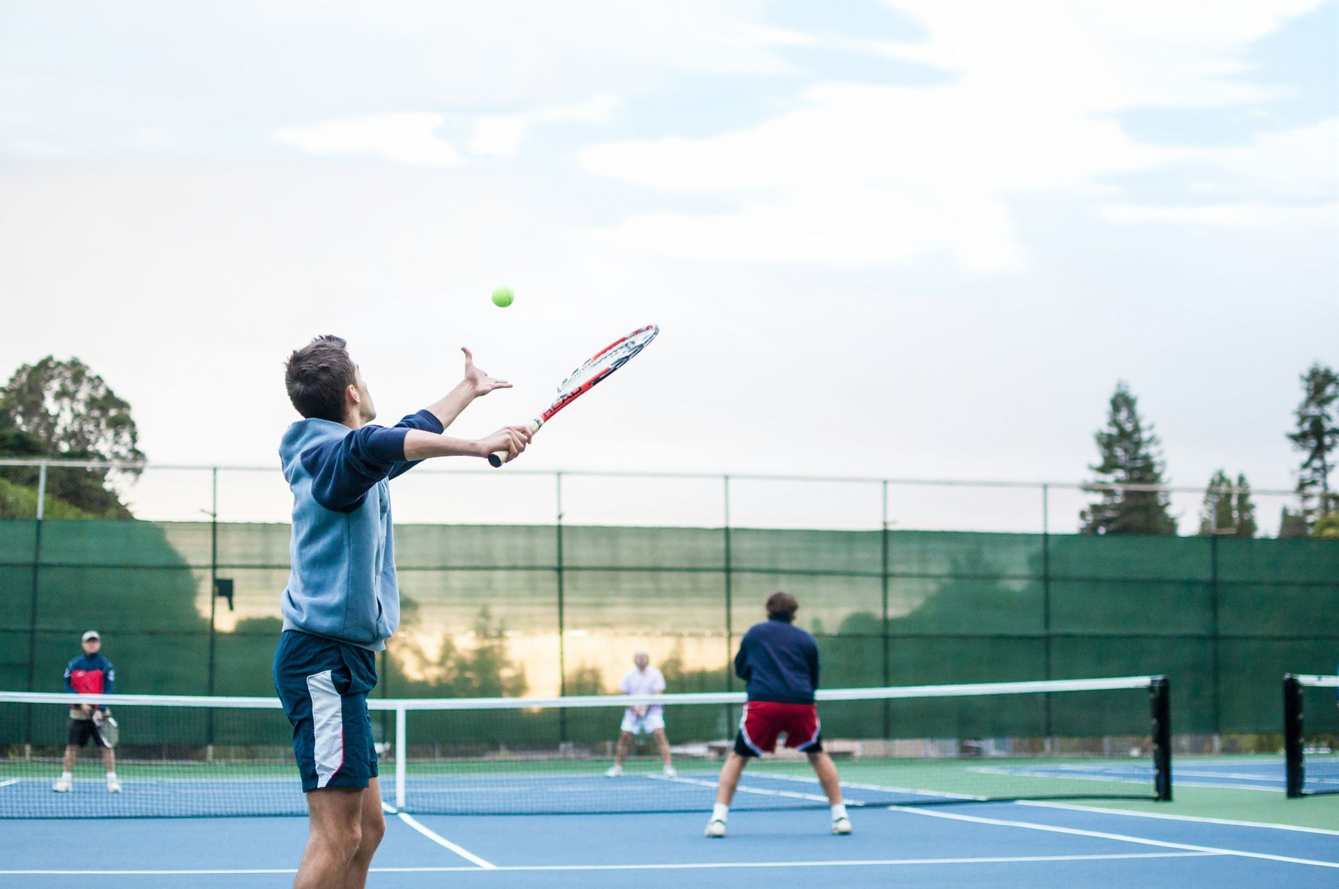 Two men are playing tennis on a tennis court.