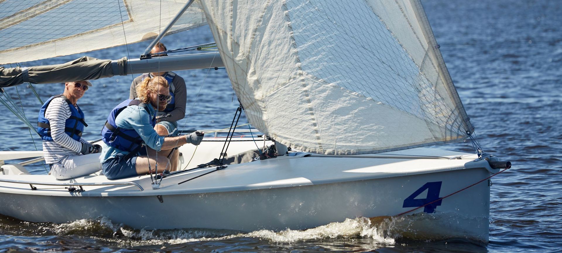 A group of people are sailing a small boat in the water.