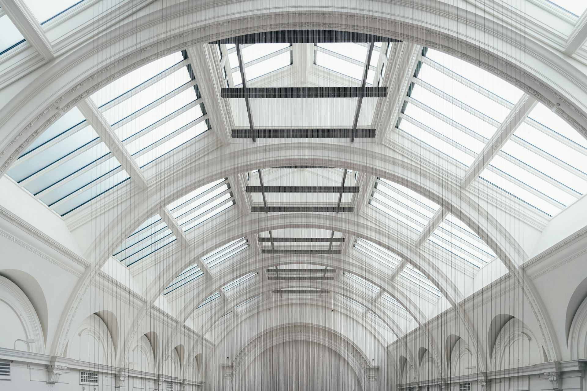 The ceiling of a building with a lot of windows and arches.