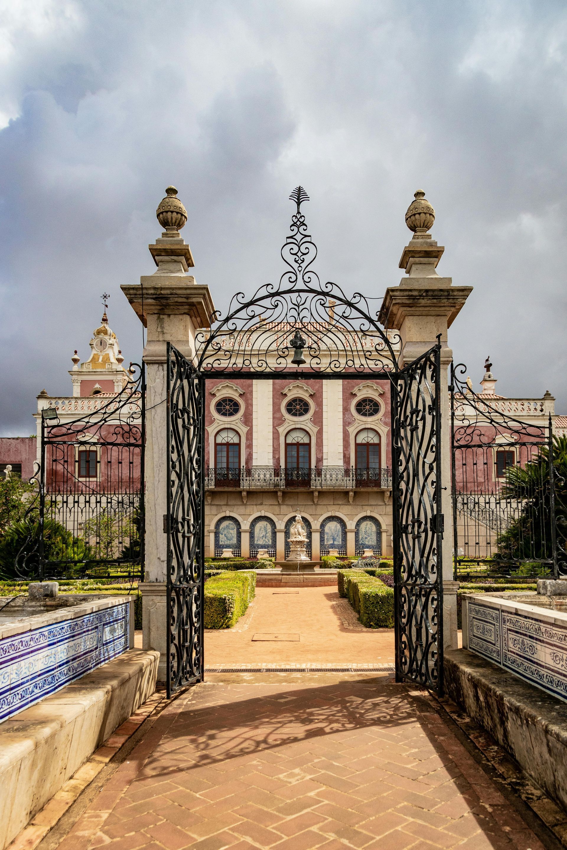 A large building with a wrought iron gate leading to it.