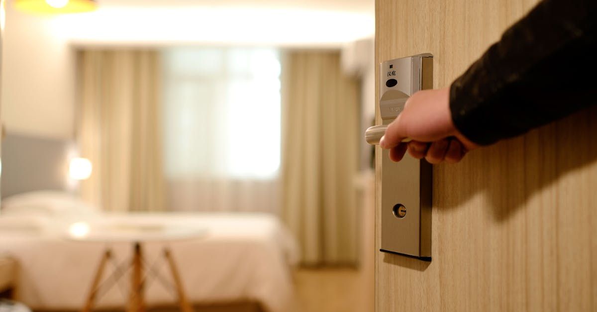 A person is opening a hotel room door with a key.