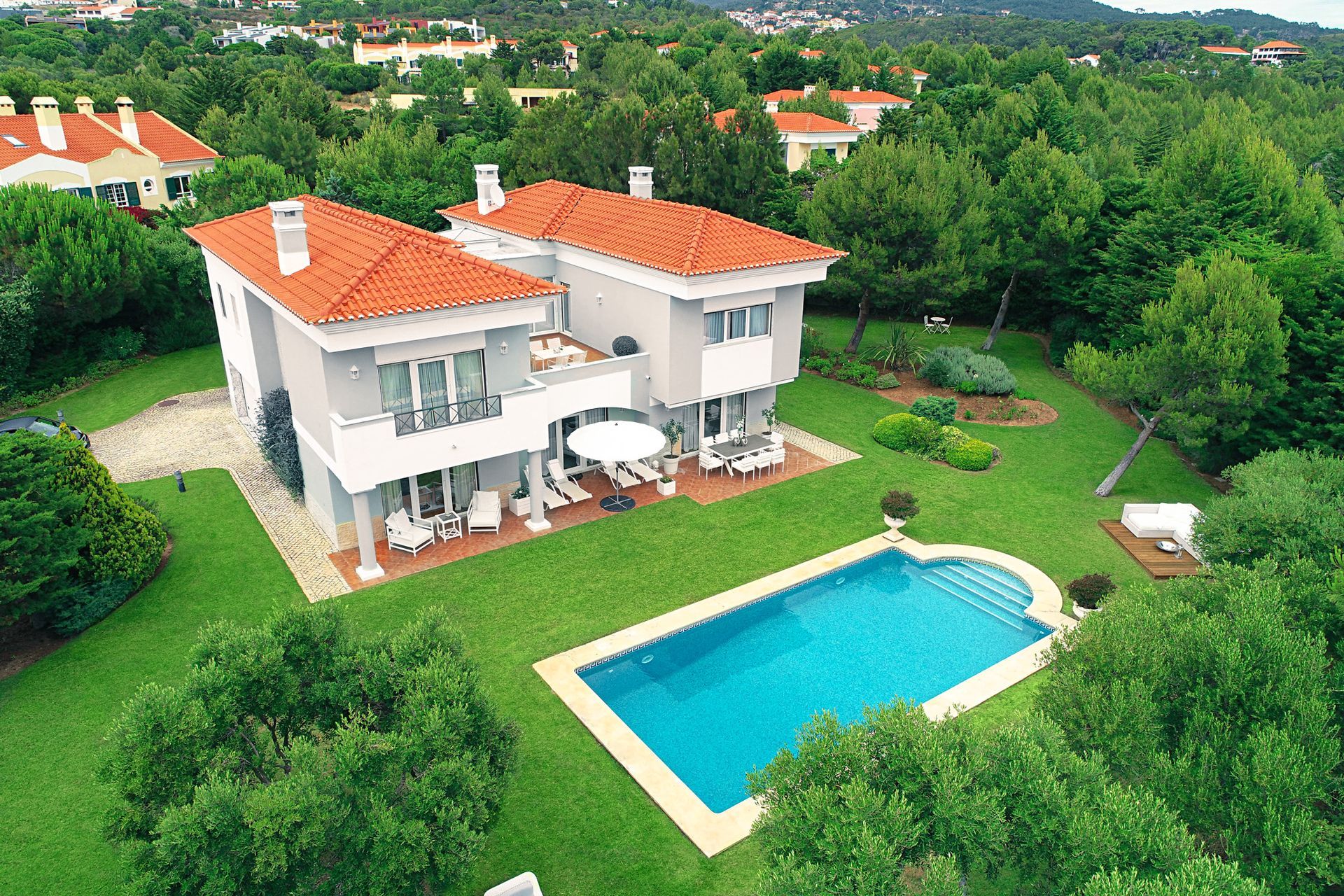 An aerial view of a house with a large swimming pool in the backyard.