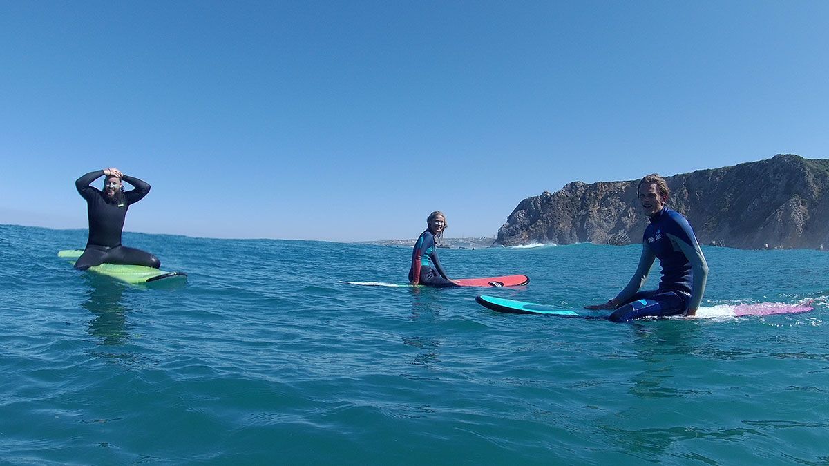 A group of people are sitting on surfboards in the ocean.