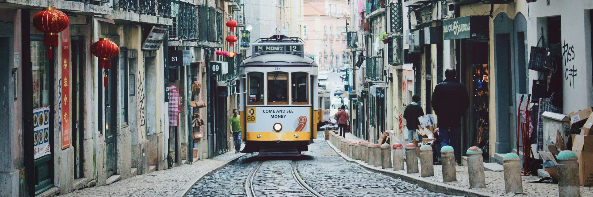 a trolley is driving down a cobblestone street in a city . American Buyers property 