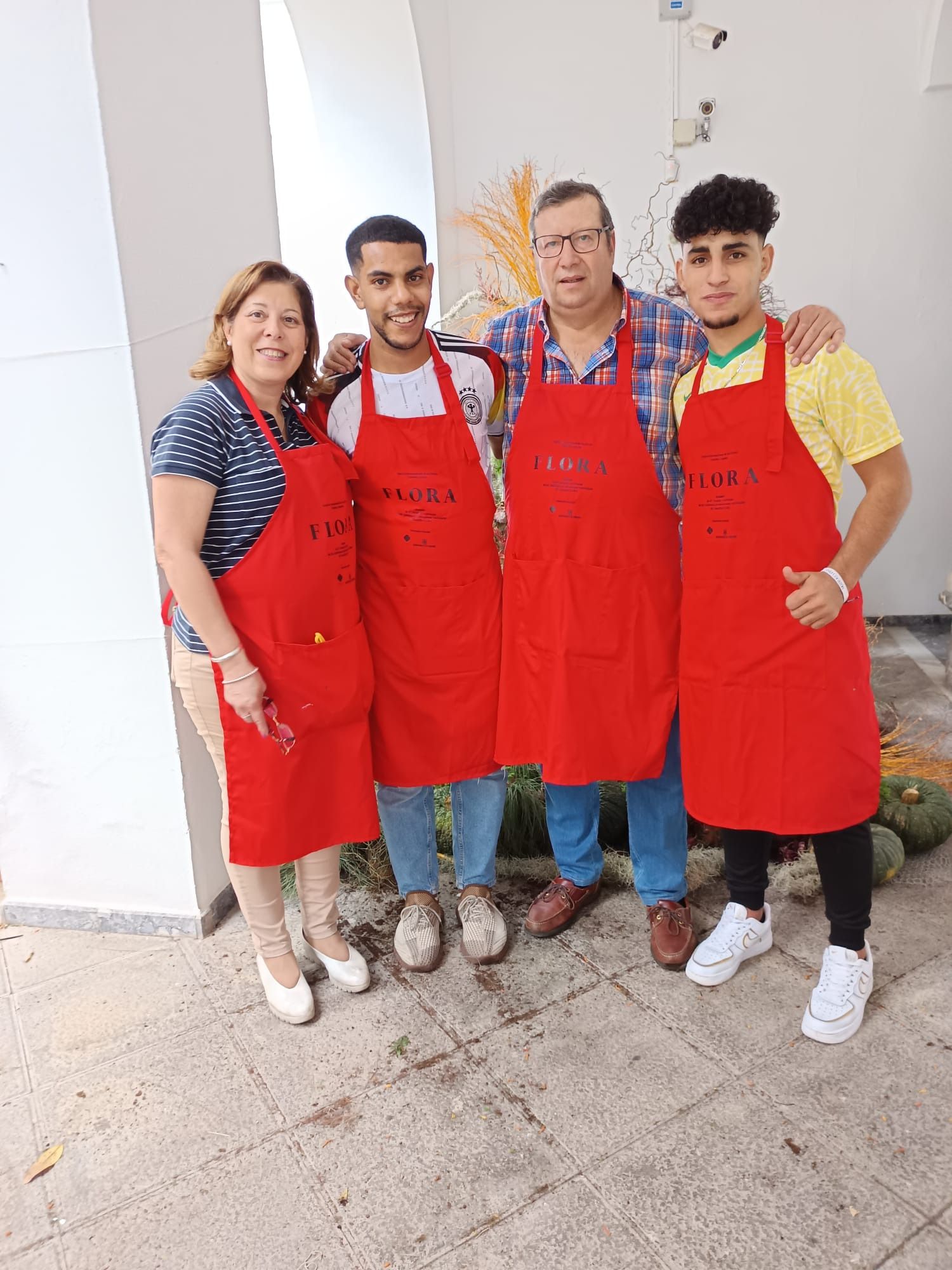 Un grupo de personas vestidas con delantales rojos posan para una fotografía.