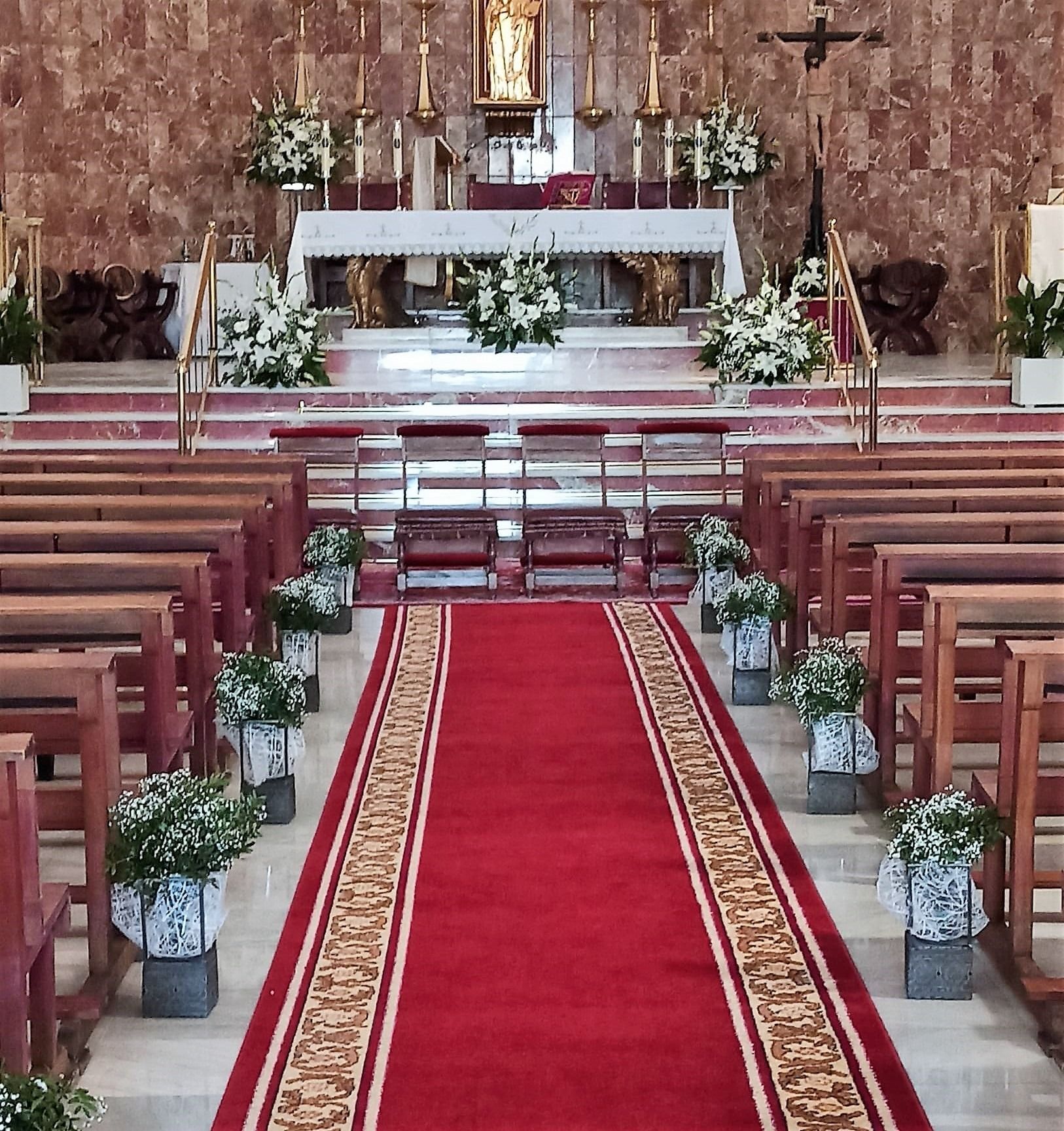 Una iglesia con una alfombra roja que conduce al altar