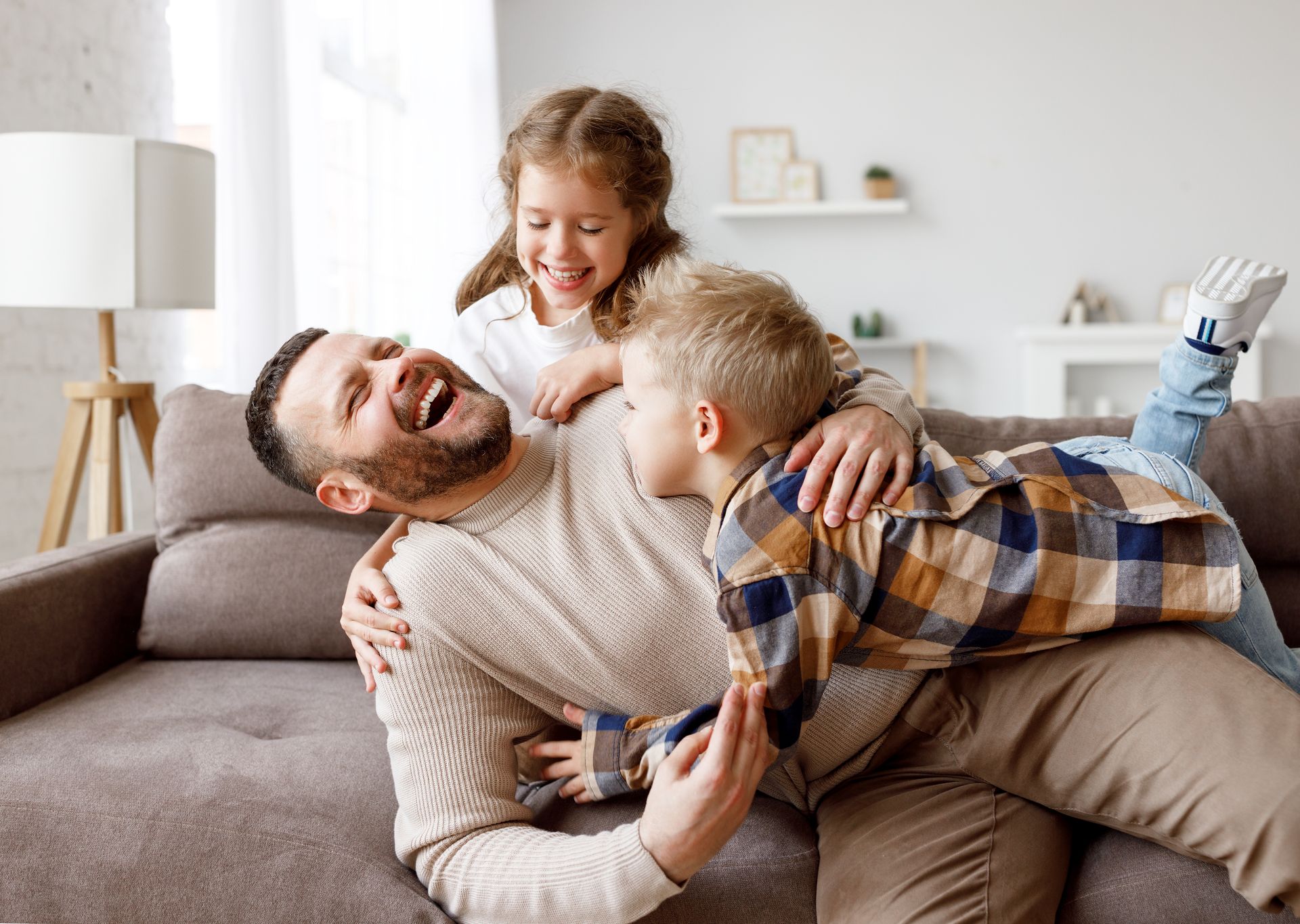 Dans un salon lumineux, la famille, assise en groupe sur un canapé, riait aux éclats.