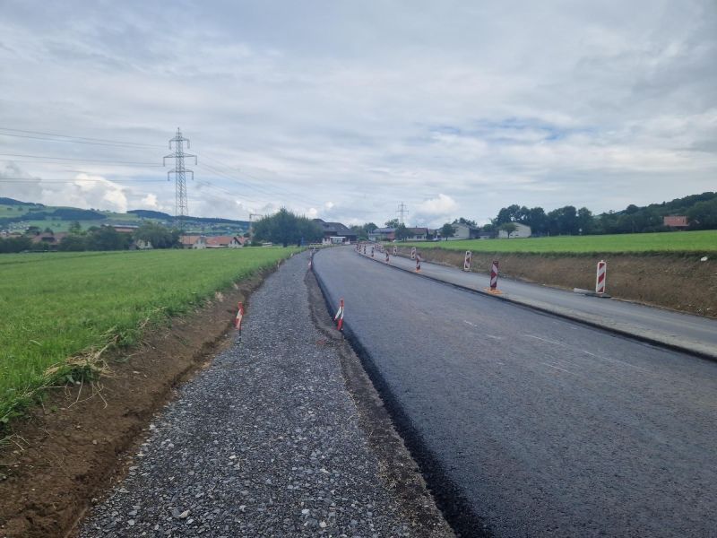 Mitten auf einem Feld wird eine Strasse gebaut.