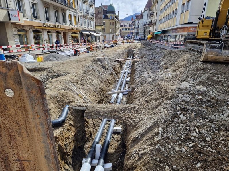 Eine Baustelle mit vielen Rohren im Dreck.