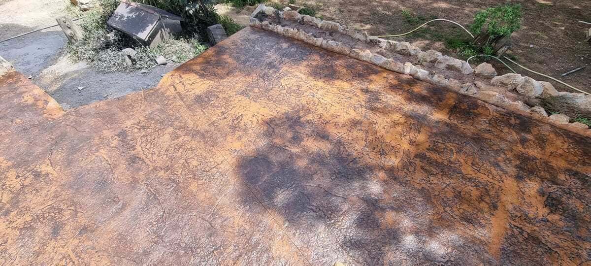 Superficie de metal oxidada, desgastada y marrón con sombras oscuras, posiblemente un techo o una estructura exterior.