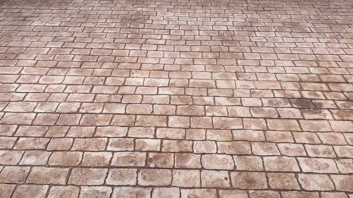 Patrón de adoquines de ladrillo marrón, ligeramente húmedo, desde una perspectiva de ángulo bajo.