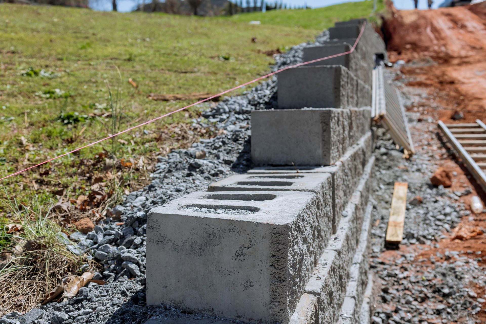 Se están colocando bloques de hormigón para construir un muro de contención en una ladera.
