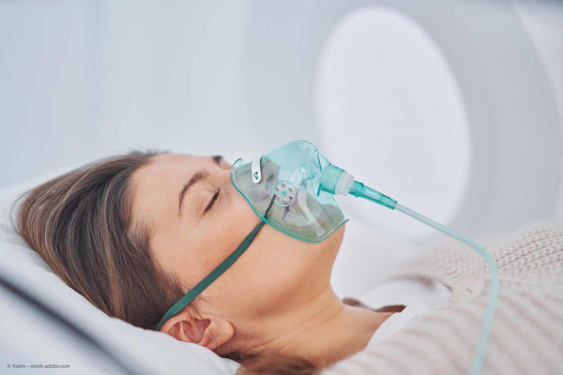 Frau liegt mit einer Sauerstoffmaske