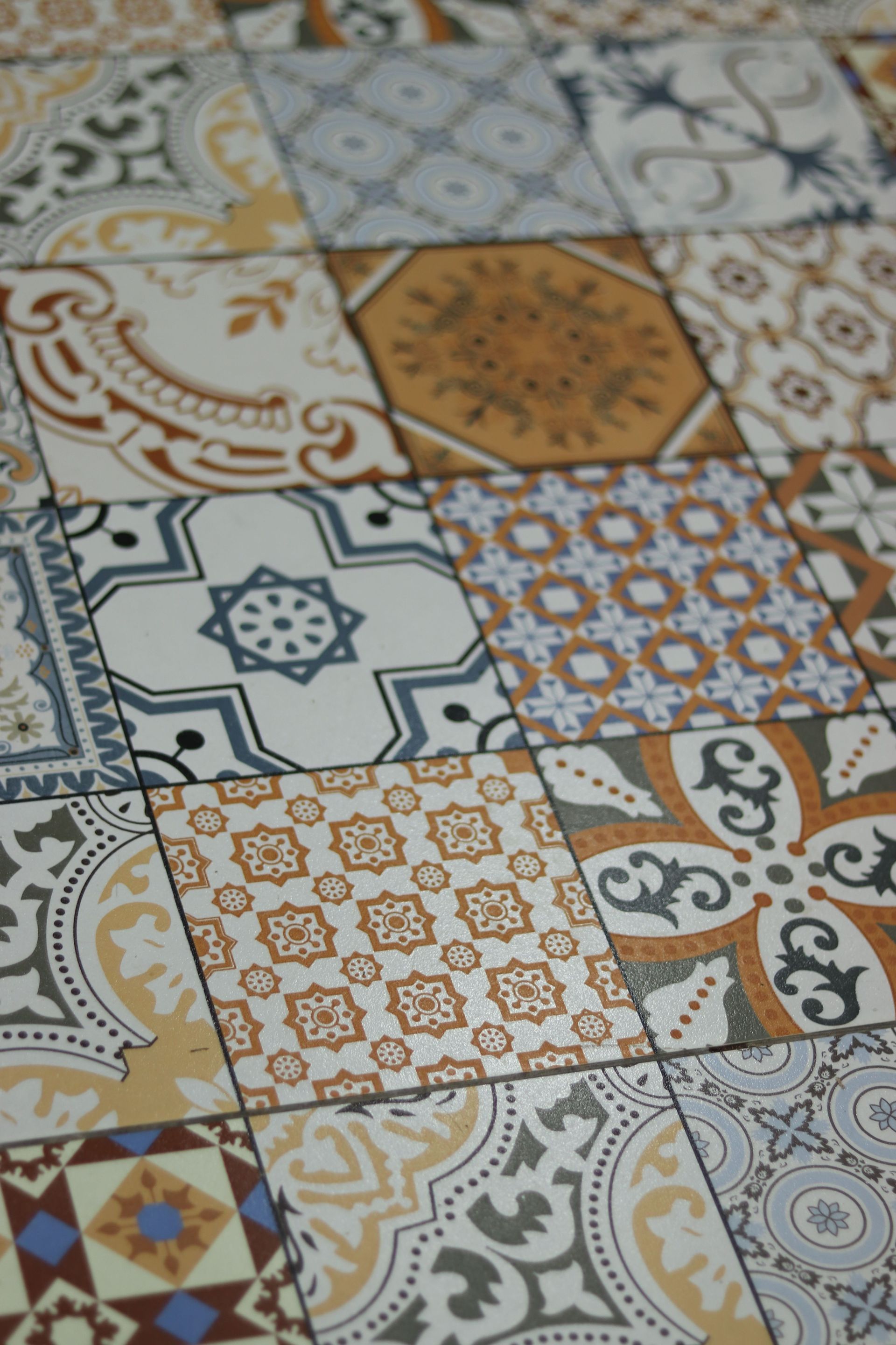 Carrelage en céramique à motifs géométriques et floraux blancs, bleus et moutarde