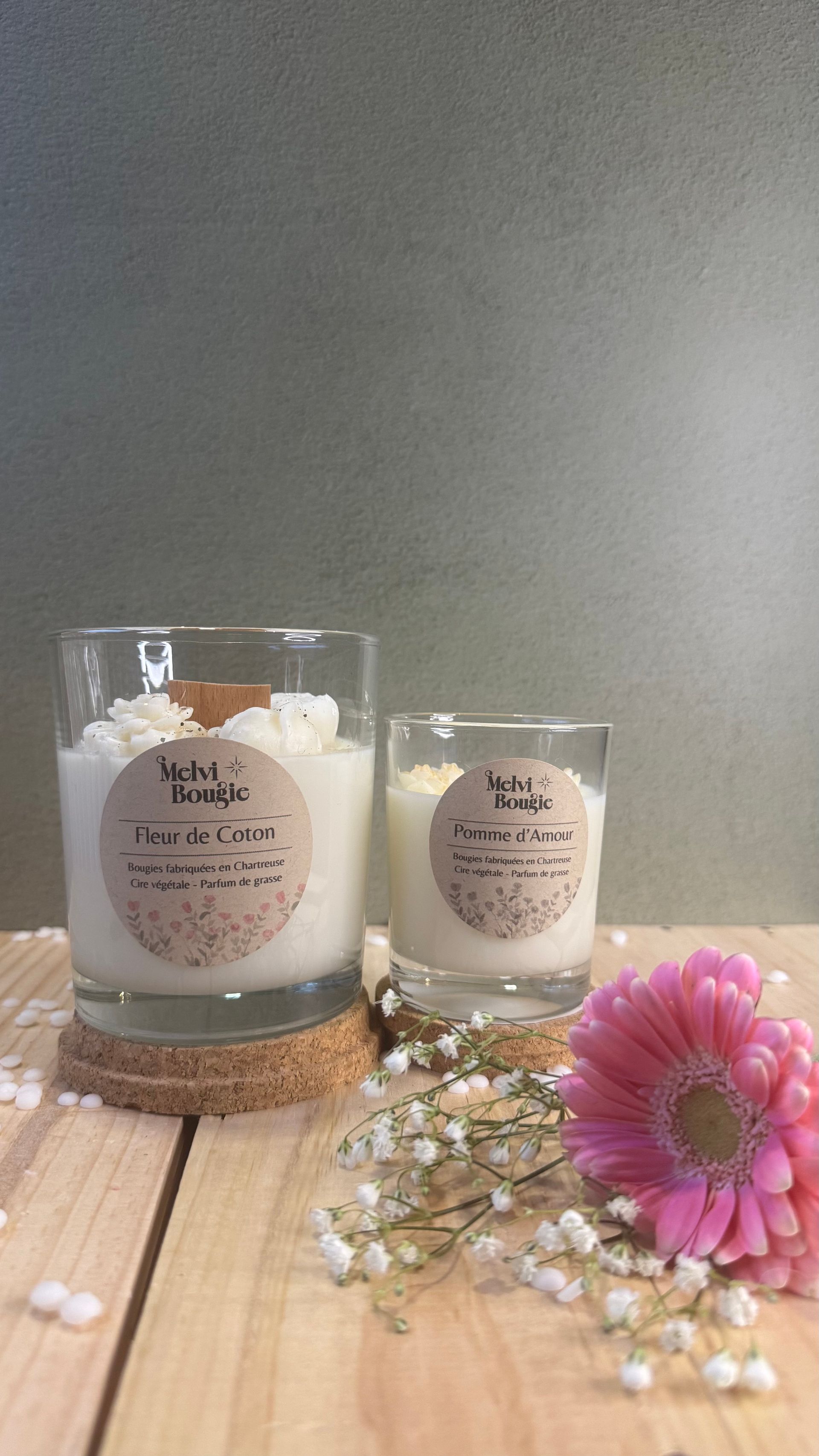 Sapin de Noël en céramique illuminé et bougies sur une surface blanche et moelleuse.