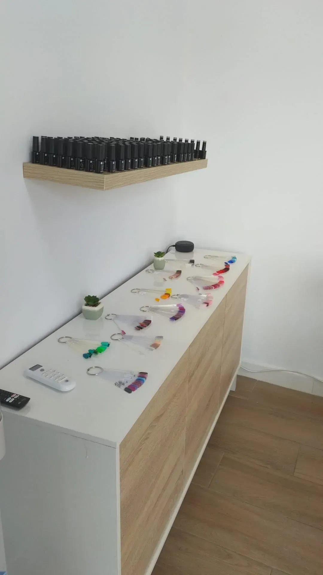 Una mesa con muchos controles remotos encima en una habitación.