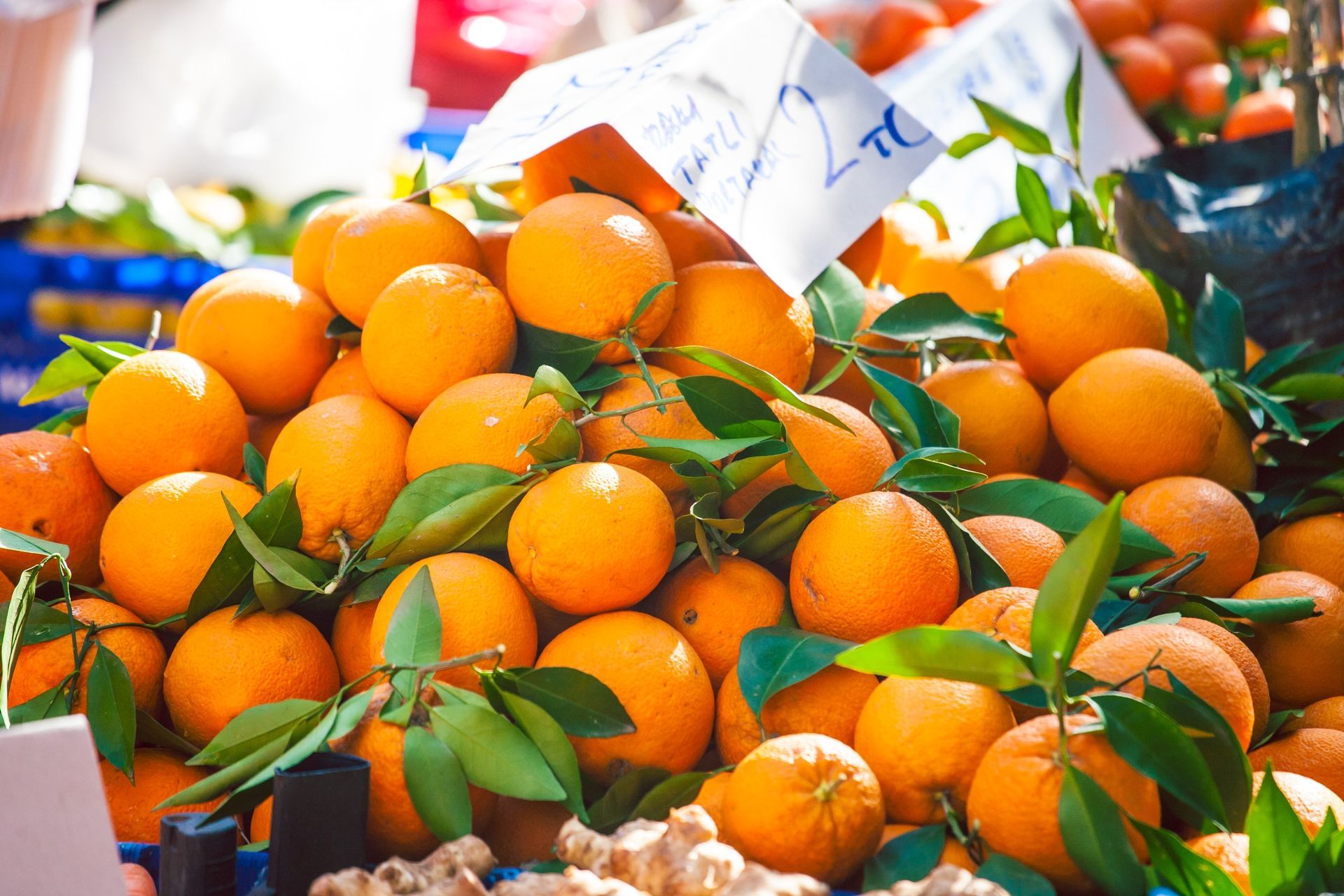 Un montón de naranjas con hojas están sobre una mesa.