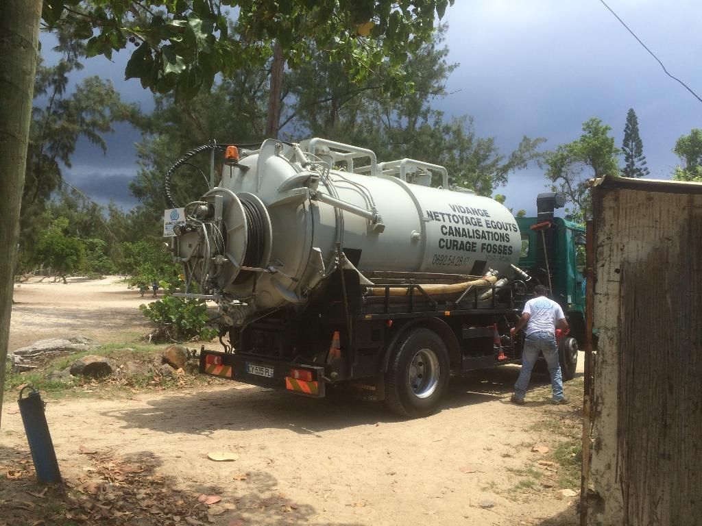 Camion de Vidange Express blanc sur un terrain à La Réunion.