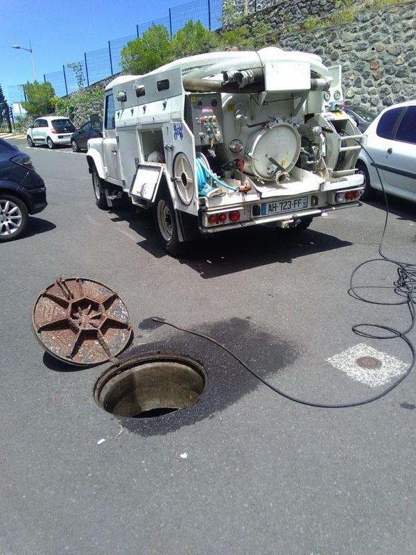 Sonde et caméra près d'une bouche d'égout ouverte.