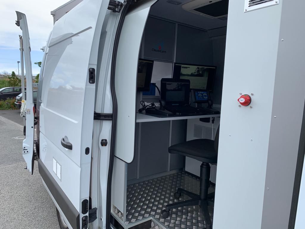 Van blanc à la porte ouverte dans lequel on aperçoit un centre de commande pour inspecter les canalisations.