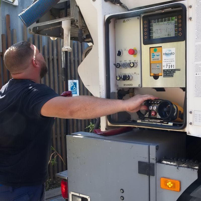 Professionnel actionnant des boutons à l'arrière d'un camion de vidange.
