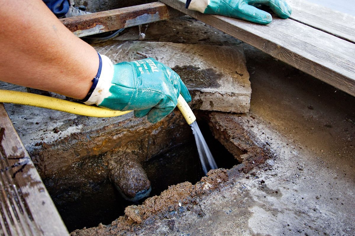 Professionnel lavant une installation de fosse sceptique.