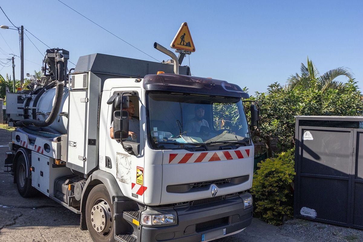 Cabine d'un camion blanc en intervention pour une vidange.