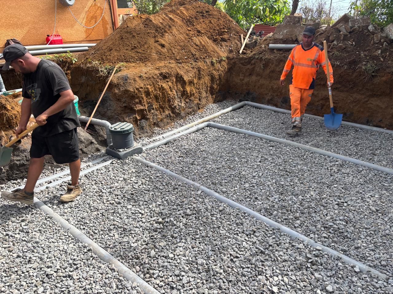Deux professionnels qui font des travaux d'installation d'un système d'assainissement.