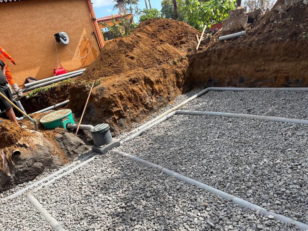 Chantier d'installation de système d'assainissement à proximité d'une maison.