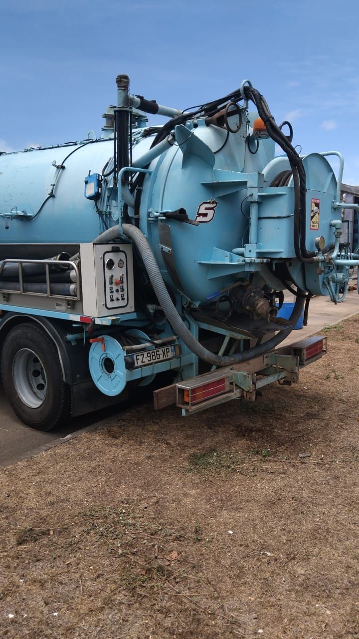 Arrière d'un camion dédié à la vidange de fosse septique de couleur bleue.