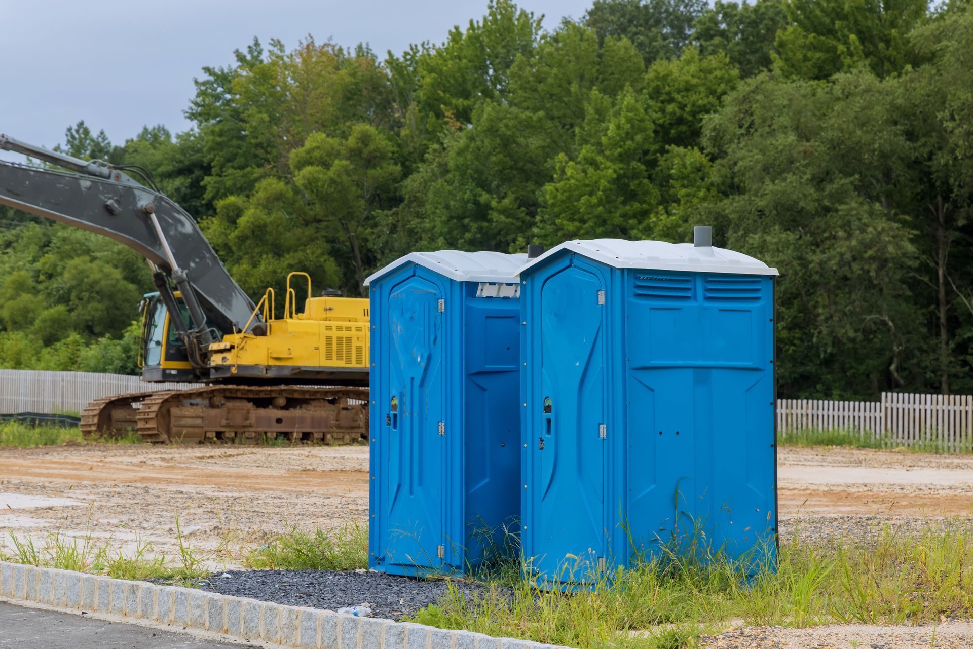 Deux cabines de WC de chantier bleues.