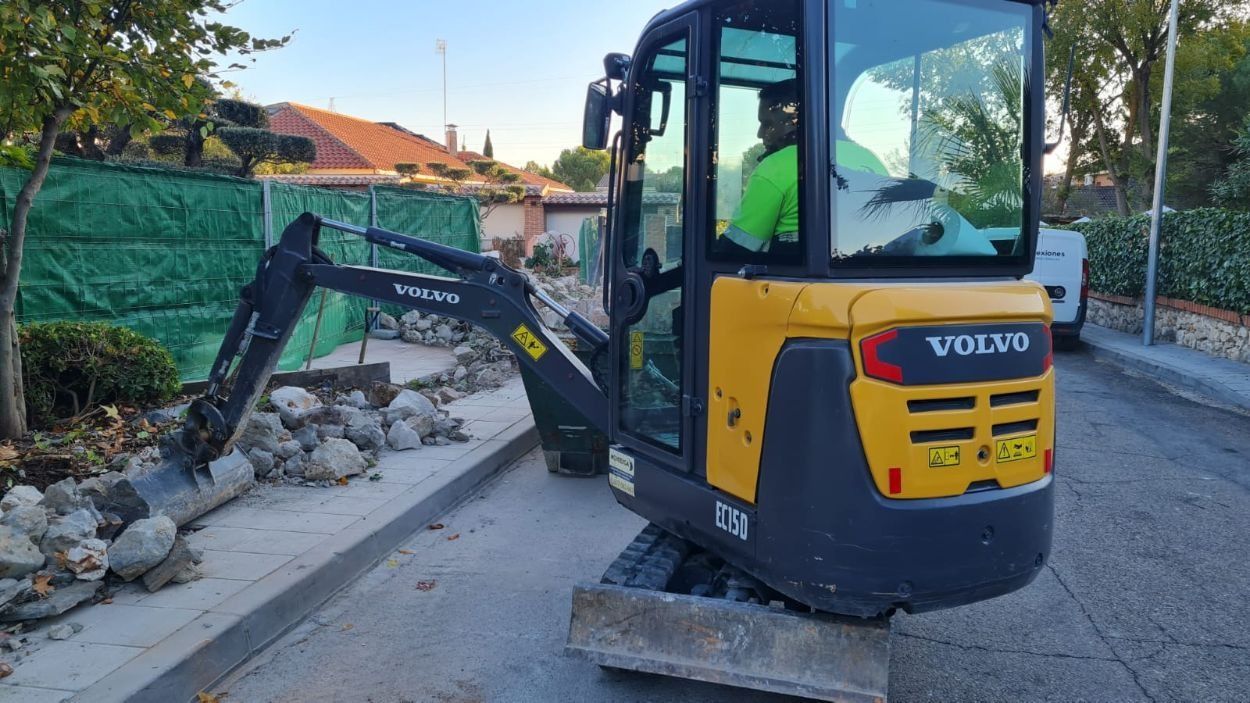 Una excavadora Volvo amarilla y negra está estacionada al costado de la carretera.