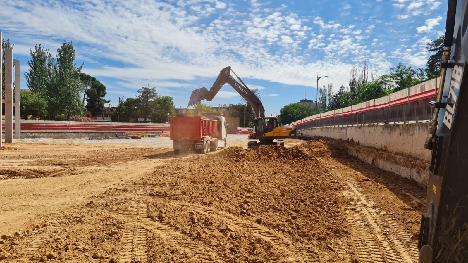 Una excavadora grande está trabajando en un camino de tierra.