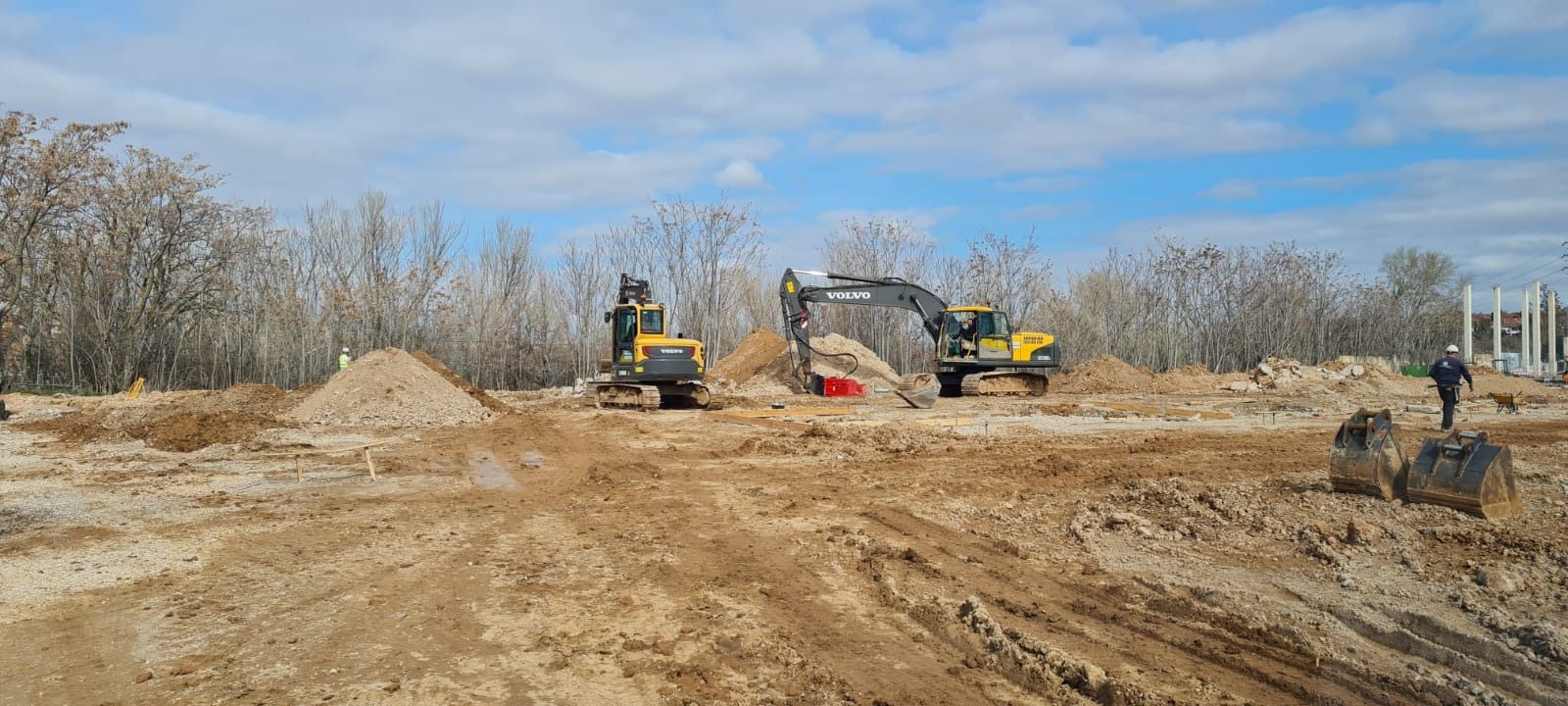Un grupo de vehículos de construcción está trabajando en un campo de tierra.