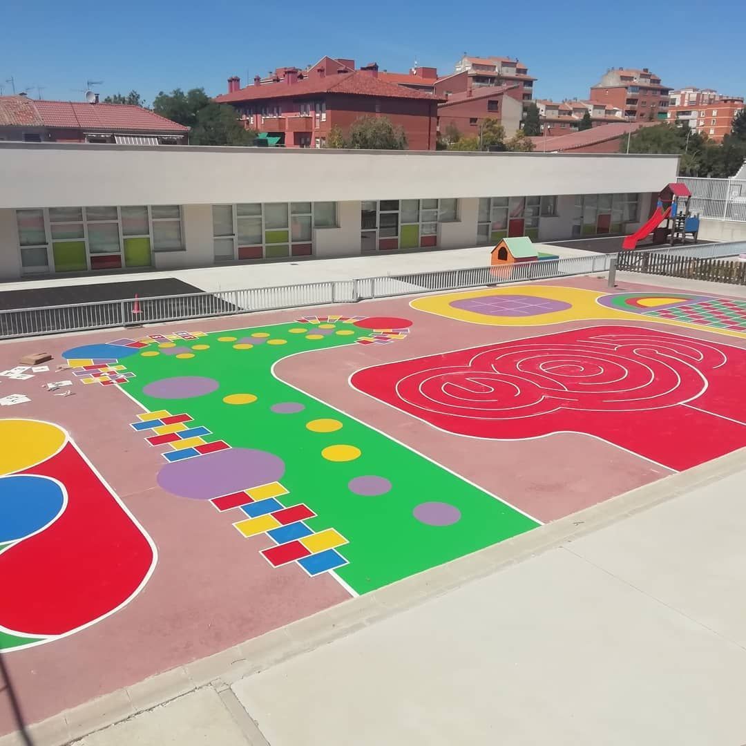 Una vista aérea de un colorido parque infantil frente a un edificio.