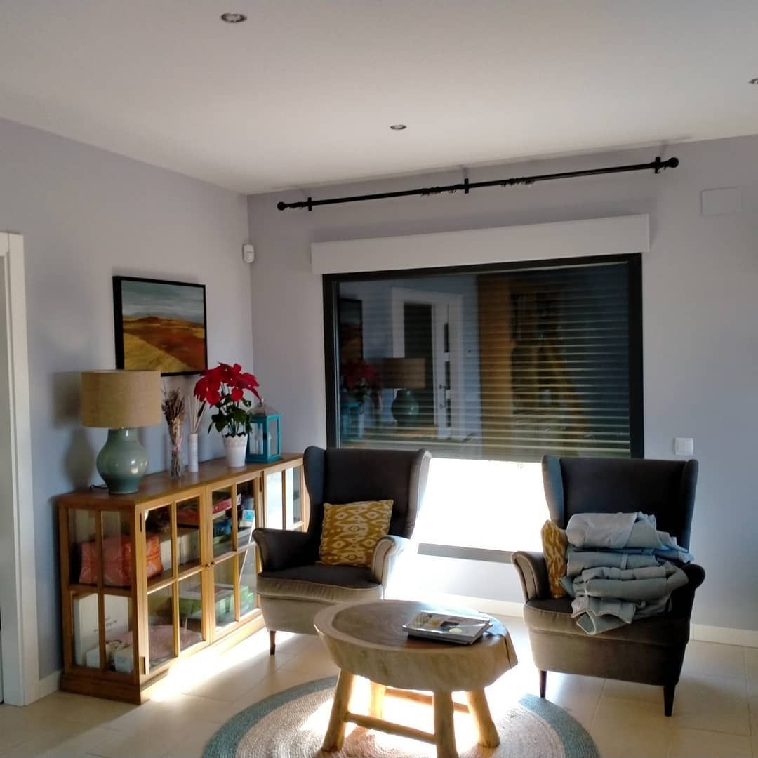Una sala de estar llena de muebles y una gran ventana.